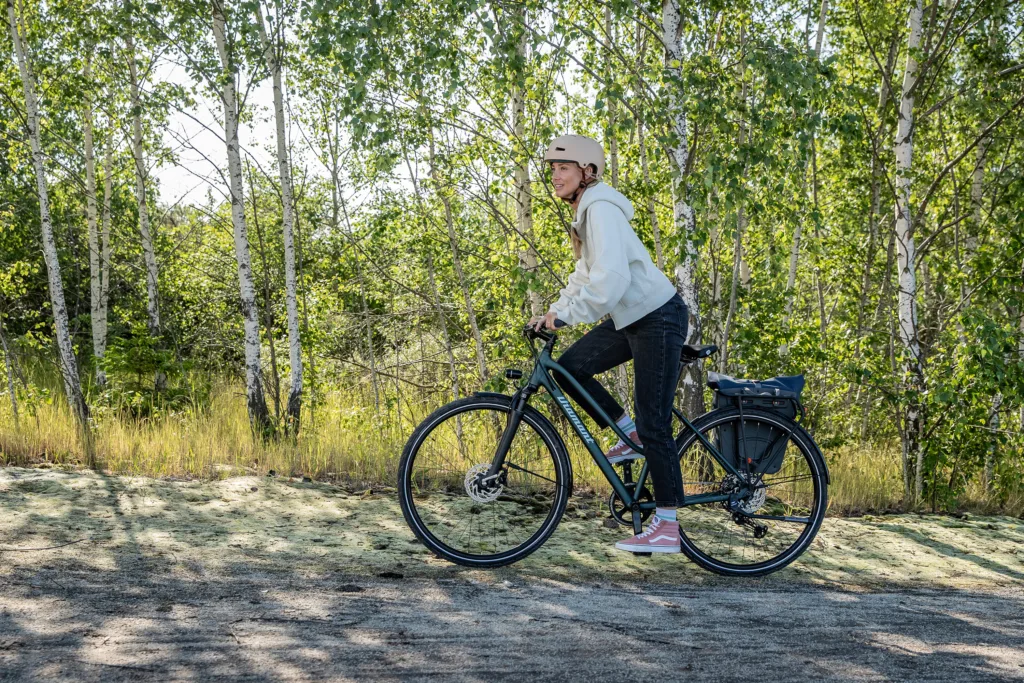 Eine Frau fährt mit einem Trekking-Rad auf einer Schotterstrasse.