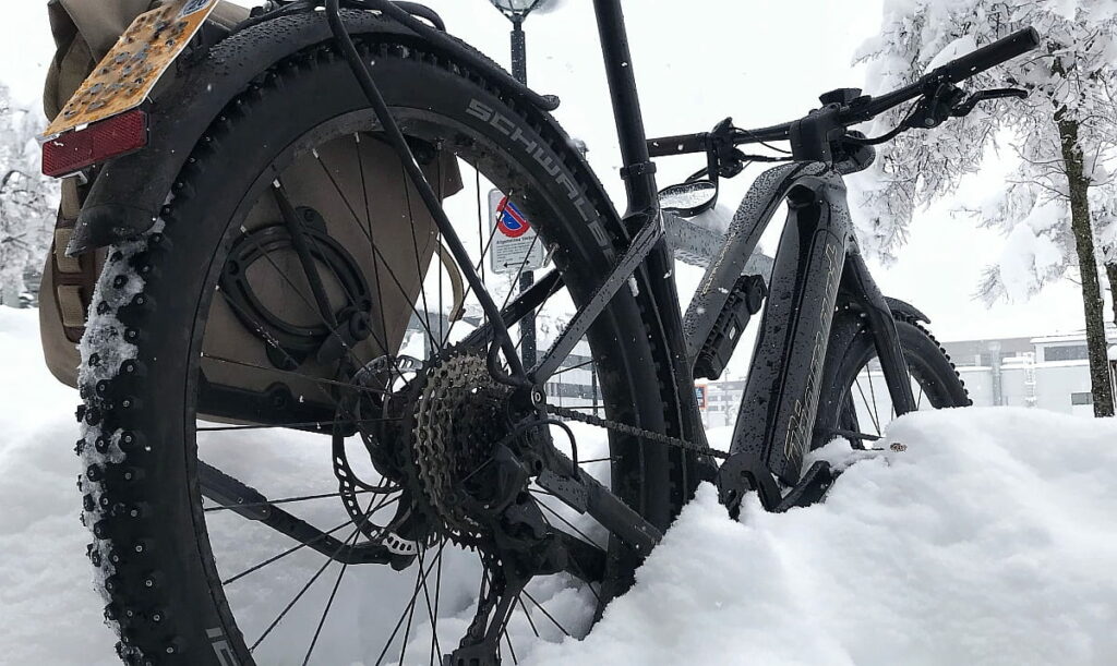 Schwarzes E-Bike steht im Schnee