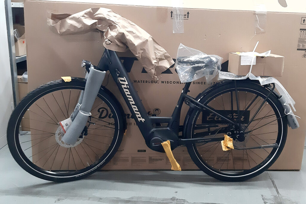 Verpacktes Fahrrad vor einer Kartonschachtel