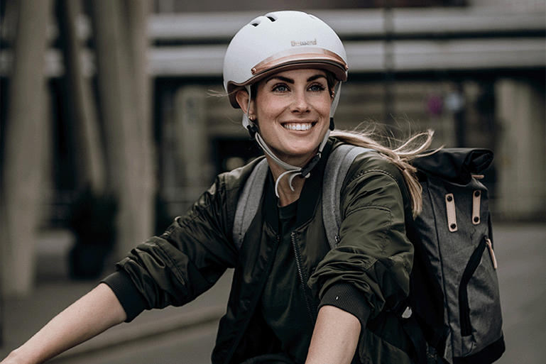 Anna Reusch lächelt in die Kamera und trägt einen Fahrradhelm