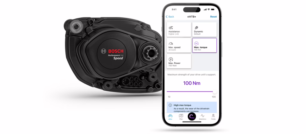 Smartphone with Bosch eBike Flow app in front of a Bosch Performance Speed Line drive unit, the screen of the app shows the motor settings interface