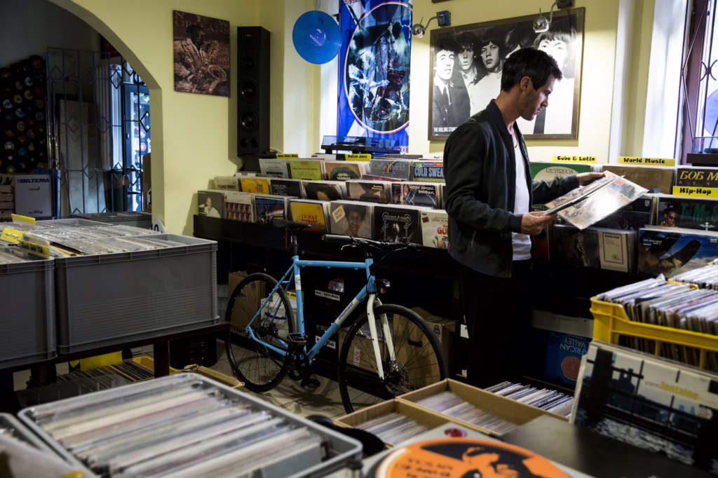 Ein Mann steht in einem Schallplattenladen. Im Hintergrund lehnt sein Diamant 134 an einem Regal mit Schallplatten.